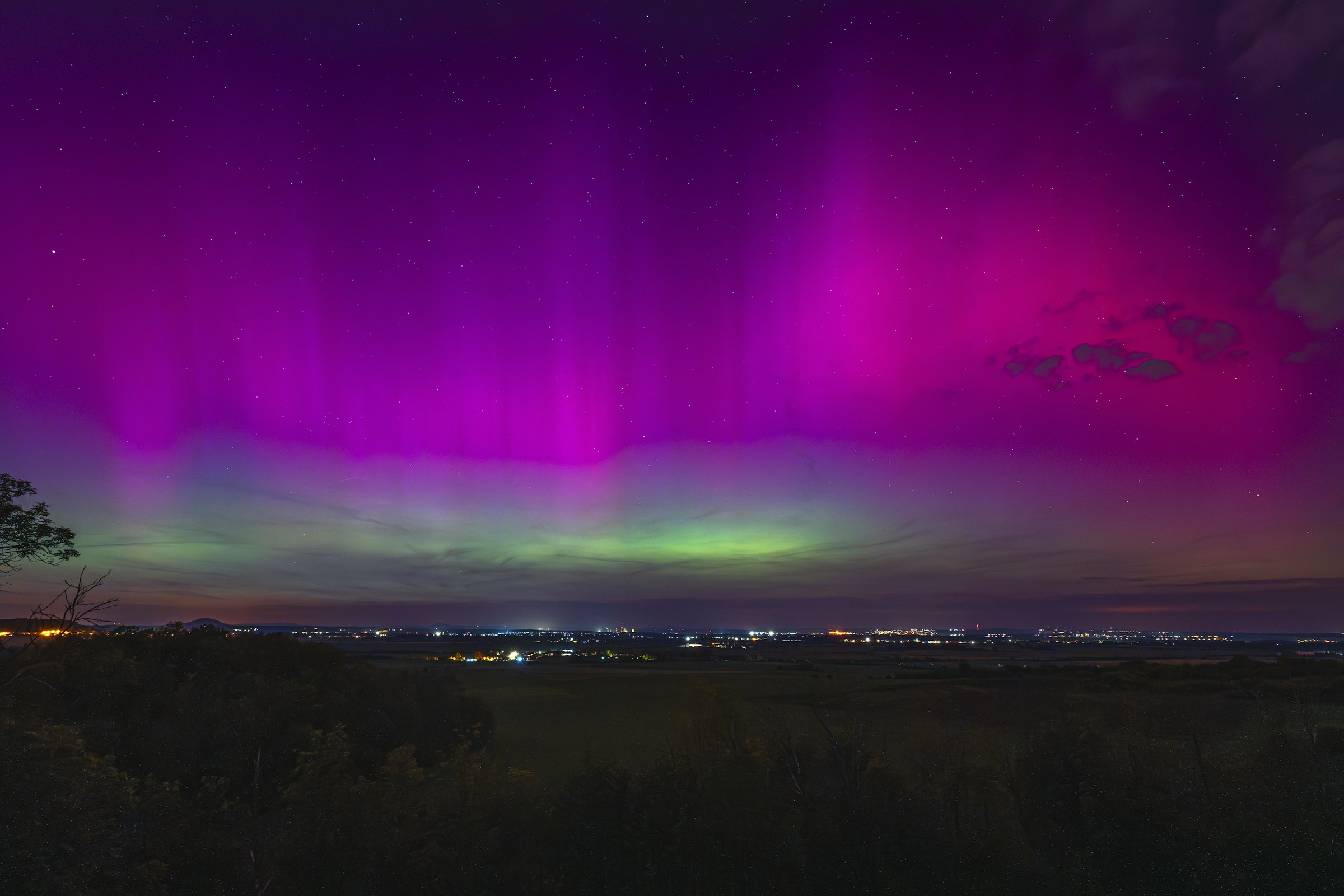 A purple aurora over a city at night, suggesting creative possibility